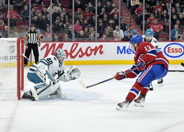 Feb 27, 2025; Montreal, Quebec, CAN; Montreal Canadiens forward Cole Caufield (13) scores the winning goal against San Jose Sharks goalie Alexandar Georgiev (40) during the overtime period at the Bell Centre. Mandatory Credit: Eric Bolte-Imagn Images