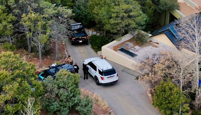 Law enforcement officials talk outside the home of actor Gene Hackman on Thursday in Santa Fe, New Mexico.