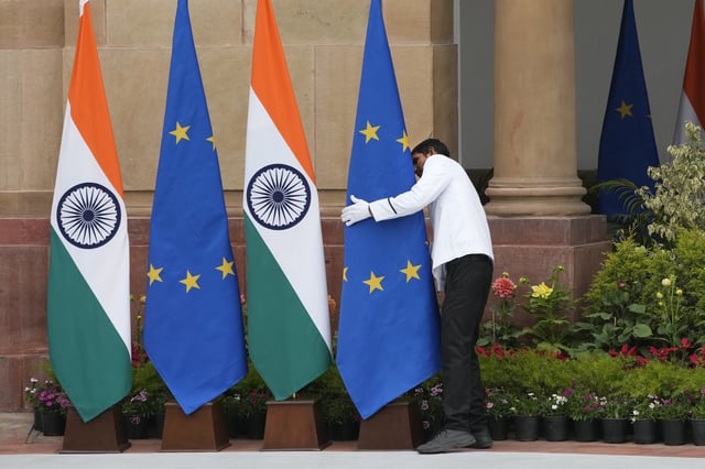 A worker adjusts a EU flag placed at the venue for the meeting between Indian Prime Minister Narendra Modi and European Commission President Ursula von der Leyen in New Delhi, India, Friday, Feb. 28, 2025. (AP Photo/Manish Swarup)