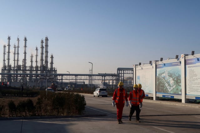 Workers walk near Yushen Yuheng power plant, a coal-fired power plant under construction, in Yulin, Shaanxi province, China November 21, 2023. REUTERS/Ella Cao/File Photo