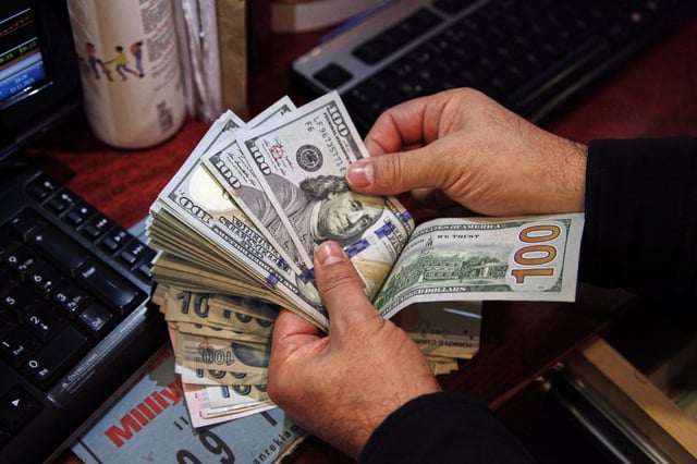 A money changer counts U.S. dollar banknotes at a currency exchange office in Ankara, Turkey November 11, 2021. REUTERS/Cagla Gurdogan/File Photo