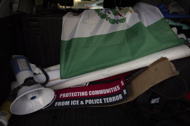 A megaphone, a Mexican flag, and signs sit in the trunk of Ron Gochez's car after he finished searching for ICE activity in a neighborhood in Los Angeles on Thursday, Feb. 27, 2025. (AP Photo/Jae C. Hong)