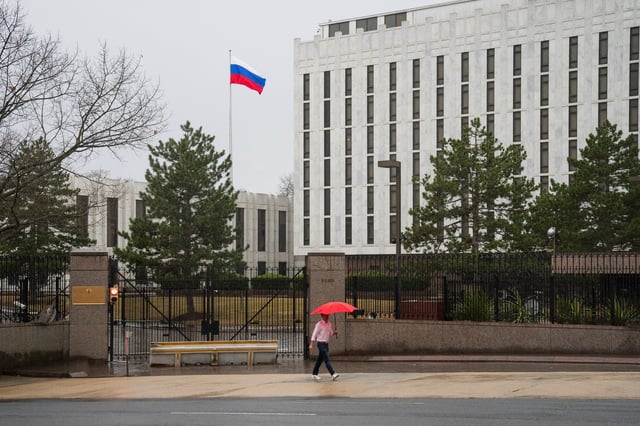 A pedestrian walks with an umbrella outside the Embassy of the Russian Federation, near the Glover Park neighborhood of Washington, U.S., February 22, 2022. REUTERS/Tom Brenner