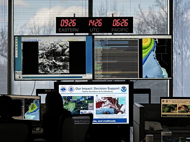 Workers in front of monitors at the National Oceanic and Atmospheric Administration (NOAA) Center for Weather and Climate Prediction headquarters in College Park, Maryland, US, on Thursday, Dec. 5, 2024. The conservative Project 2025 roadmap calls for slashing NOAA funding at a time when China is investing heavily in climate research. Photographer: Michael A. McCoy/Bloomberg