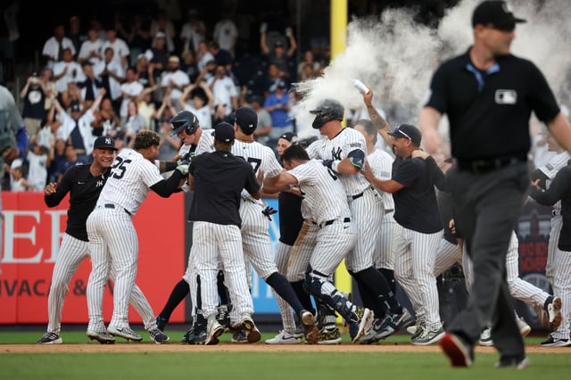 DJ LeMahieu #26 of the New York Yankees is congratulated by teammates after hitting a walk off single during the game against the Toronto Blue Jays at Yankee Stadium on August 4, 2024, in New York.