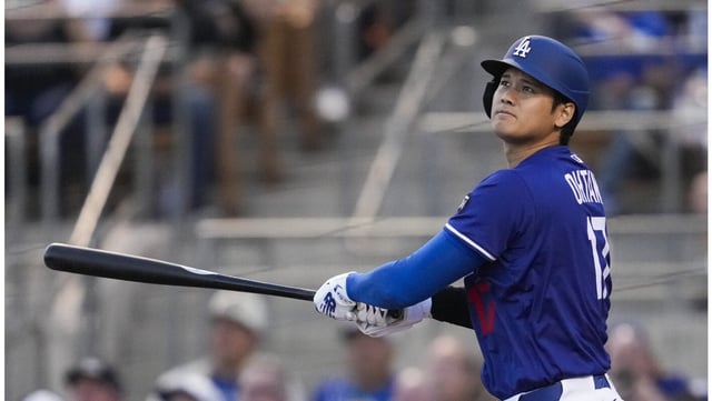 Dodgers designated hitter Shohei Ohtani watches the flight of his opposite-field home run during the first inning of their Cactus League game against the Angels on Friday night in Glendale, Ariz. (AP Photo/Ashley Landis)