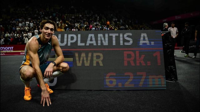 Swedish athlete Armand Duplantis poses next to a screen displaying his record. (AFP)