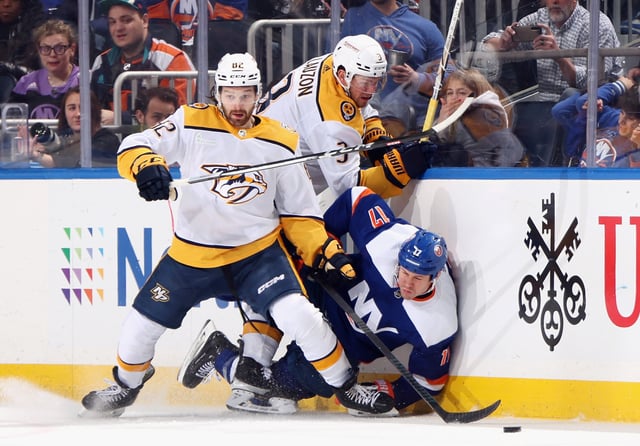 Jeremy Lauzon #3 of the Nashville Predators hits Matt Martin #17 of the New York Islanders during the third period at UBS Arena on April 06, 2024 in Elmont, New York.