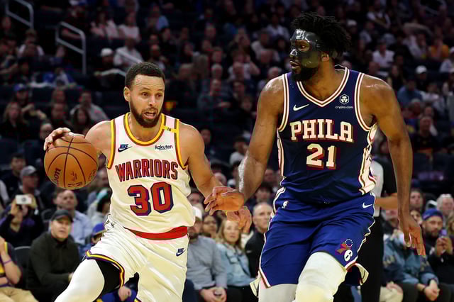SAN FRANCISCO, CALIFORNIA - JANUARY 02: Stephen Curry #30 of the Golden State Warriors is guarded by Joel Embiid #21 of the Philadelphia 76ers during the second half at Chase Center on January 02, 2025 in San Francisco, California.