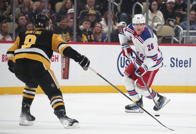 Feb 23, 2025; Pittsburgh, Pennsylvania, USA;  New York Rangers left wing Jimmy Vesey (26) skates with the puck against Pittsburgh Penguins left wing Michael Bunting (8) during the third period at PPG Paints Arena. Charles LeClaire-Imagn Images/File Photo