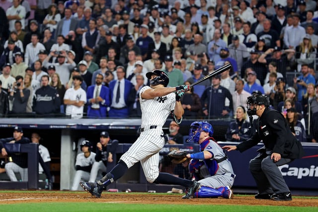 Oct 30, 2024; New York, USA; New York Yankees designated hitter Giancarlo Stanton (27) hits an RBI sacrifice fly during the sixth inning against the Los Angeles Dodgers in game four of the 2024 MLB World Series at Yankee Stadium. Brad Penner-Imagn Images/File Photo