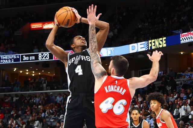 Mar 1, 2025; Memphis, Tennessee, USA; San Antonio Spurs guard De'Aaron Fox (4) shoots as Memphis Grizzlies guard John Konchar (46) defends during the third quarter at FedExForum. Mandatory Credit: Petre Thomas-Imagn Images