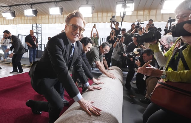 Conan O&#39;Brien, host of Sunday&#39;s 97th Academy Awards, helps to roll out the red carpet for the show at the Dolby Theatre on Wednesday, Feb. 26, 2025, in Los Angeles.