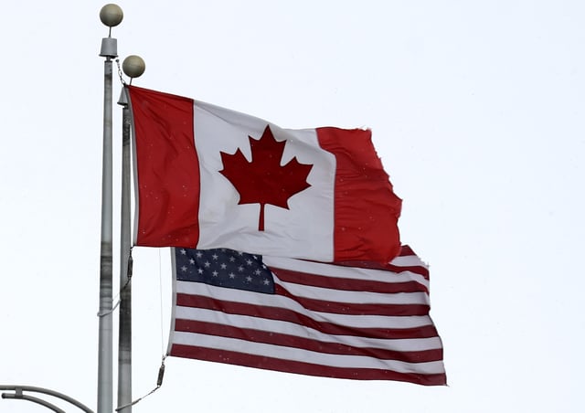 A Canadian flag flies next to the American one at the Lewiston-Queenston border crossing bridge on February 04, 2025 in Niagara Falls, Canada.