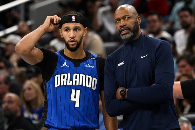 Orlando Magic head coach Jamahl Mosley, right, gives instructions to guard Jalen Suggs (4) during the first half of an Emirates NBA Cup basketball game against the Philadelphia 76ers, Friday, Nov. 15, 2024, in Orlando, Fla. (AP Photo/Phelan M. Ebenhack)