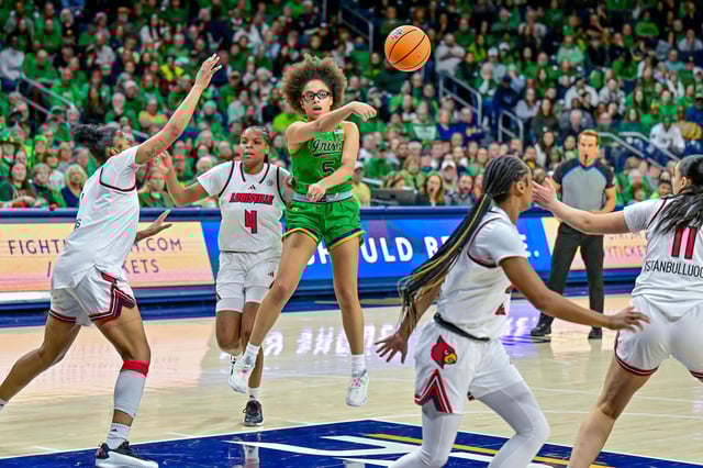 Mar 2, 2025; South Bend, Indiana, USA; Notre Dame Fighting Irish guard Olivia Miles (5) passes as Louisville Cardinals forward Mackenly Randolph (4) defends in the second half at the Purcell Pavilion. Matt Cashore-Imagn Images