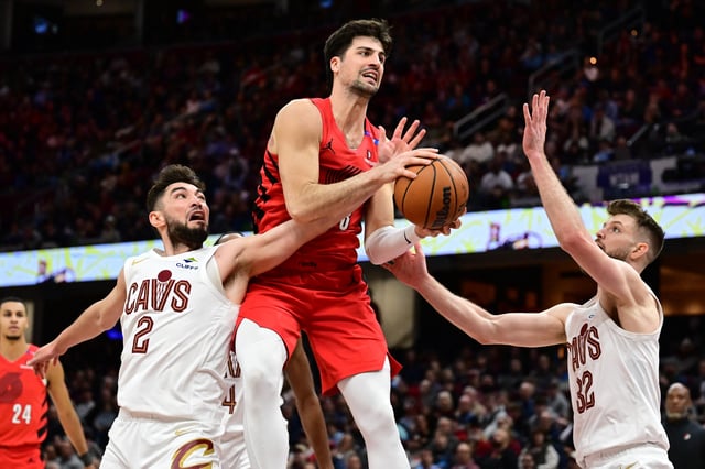Mar 2, 2025; Cleveland, Ohio, USA; 
Portland Trail Blazers forward Deni Avdija (8) drives to the basket against Cleveland Cavaliers guard Ty Jerome (2) and forward Dean Wade (32) during the second half at Rocket Arena. Mandatory Credit: Ken Blaze-Imagn Images