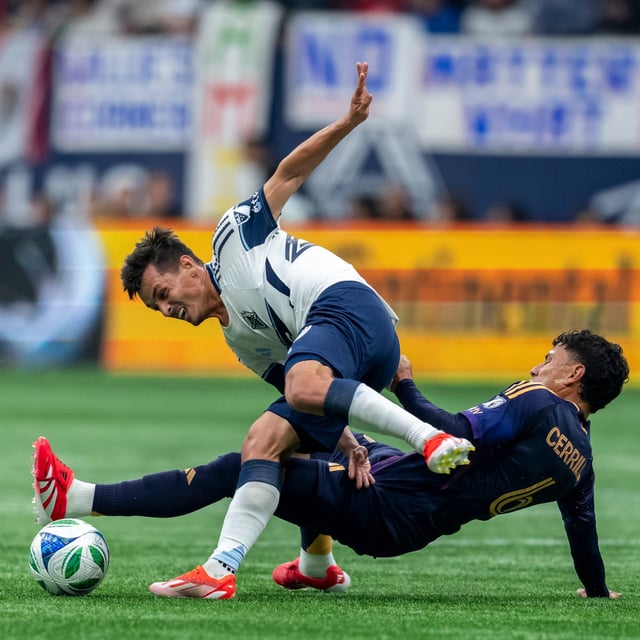 Los Angeles Galaxy's Edwin Cerrillo (6) trips Vancouver Whitecaps' Andres Cubas (20) during the first half of an MLS soccer match in Vancouver, B.C., Sunday, March 2, 2025. THE CANADIAN PRESS/Ethan Cairns