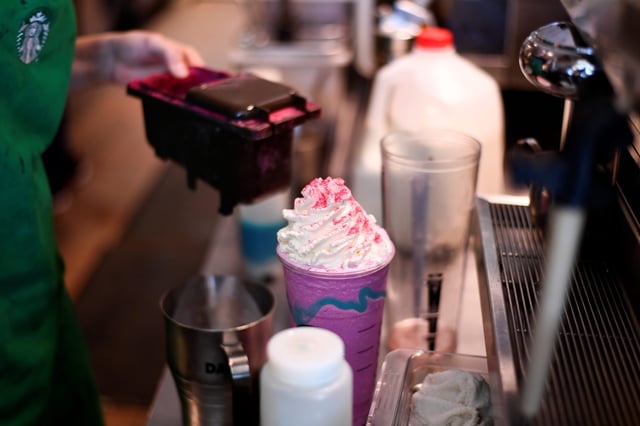 A Starbucks barista makes a Unicorn Frappuccino drink for a customer on April 21, 2017, in Austin, Texas.
