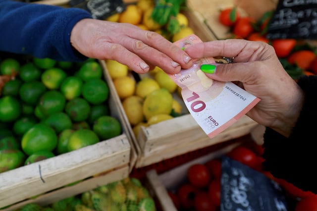 A shopper pays with a ten Euro bank note at a local market in Aix-en-Provence, France, January 16, 2025. REUTERS/Manon Cruz/file Photo