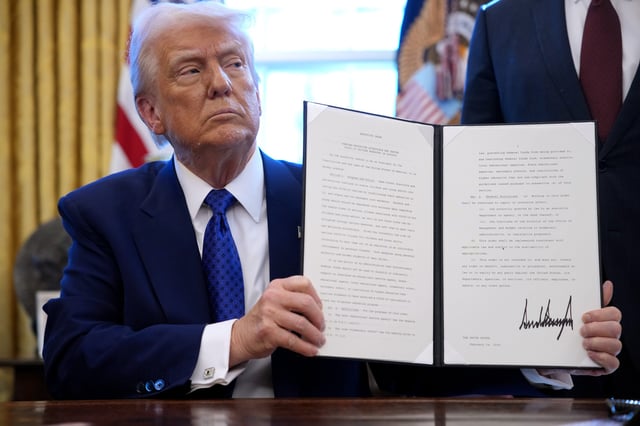 U.S. President Donald Trump signs an executive in the Oval Office at the White House on February 14, 2025 in Washington, DC.