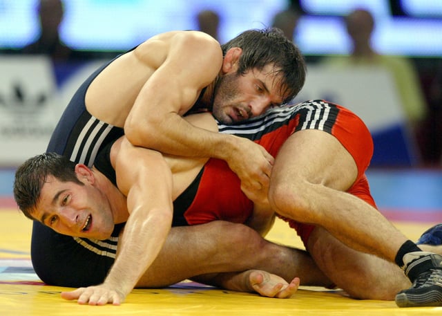 Olympic winner and world champion Russian Buvaisar Saitiev (blue) fights against Hungarian Arpad Ritter (red) during their free style 74 kg category final of the World Wrestling Championships in Budapest, 27 September 2005.