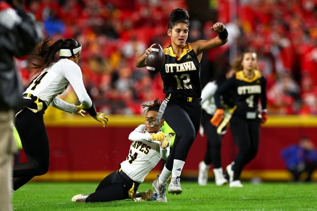 Olivia Cadiz #12 of the Ottawa University Braves and Susann Kaufmann #14 play in a women's flag football game at halftime between the Kansas City Chiefs and the Tampa Bay Buccaneers at GEHA Field at Arrowhead Stadium, in Kansas City, Mo., on Nov. 4, 2024.