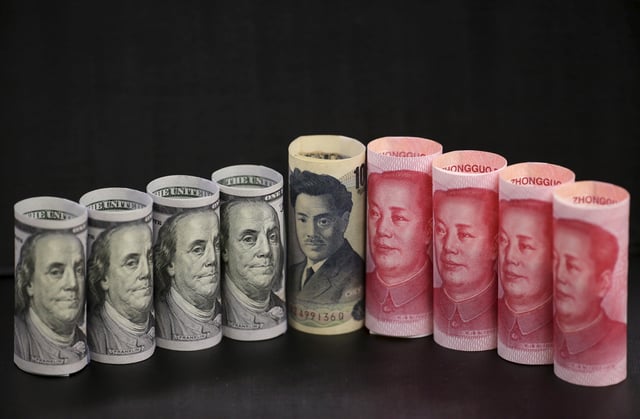 U.S. 100-dollar banknotes, Chinese 100-yuan banknotes, and a Japanese 1000-yen banknote, are seen in a picture illustration in Beijing, China, January 21, 2016. REUTERS/Jason Lee/File photo
