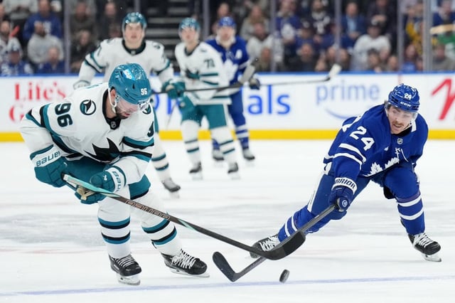 San Jose Sharks defenceman Jake Walman (96) and Toronto Maple Leafs forward Connor Dewar (24) vie for control of the puck during second period NHL hockey action in Toronto, Monday, March 3, 2025. THE CANADIAN PRESS/Nathan Denette