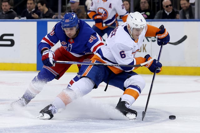 Mar 3, 2025; New York, New York, USA; New York Islanders defenseman Ryan Pulock (6) skates with the puck against New York Rangers left wing Will Cuylle (50) during the third period at Madison Square Garden. Mandatory Credit: Brad Penner-Imagn Images