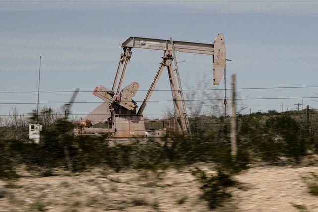 A pump jack drills oil crude from the Yates Oilfield in West Texas’s Permian Basin near Iraan, Texas, U.S., March 17, 2023. Picture taken through glass. REUTERS/Bing Guan/File photo