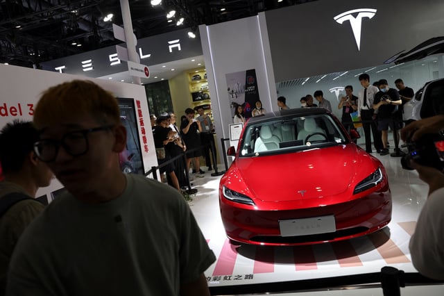 Visitors stand outside barriers surrounding Tesla's new Model 3 sedan displayed at the China International Fair for Trade in Services (CIFTIS) in Beijing, China September 2, 2023. REUTERS/Florence Lo/File Photo