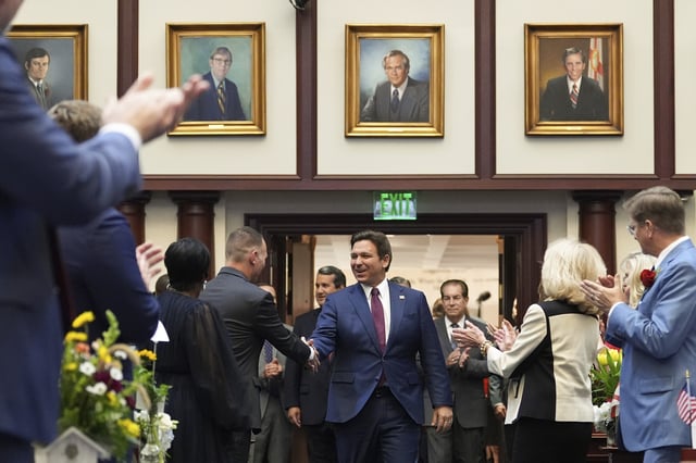 Florida Gov. Ron DeSantis shakes hands with lawmakers as he enters the house chamber to address a joint session, on the opening day of the 2025 legislative session, Tuesday, March 4, 2025, at the state capitol in Tallahassee, Fla. (AP Photo/Rebecca Blackwell)