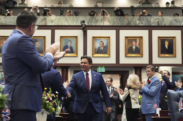 Florida Gov. Ron DeSantis shakes hands with lawmakers as he enters the house chamber to address a joint session, on the opening day of the 2025 legislative session, Tuesday, March 4, 2025, at the state capitol in Tallahassee, Fla. (AP Photo/Rebecca Blackwell)