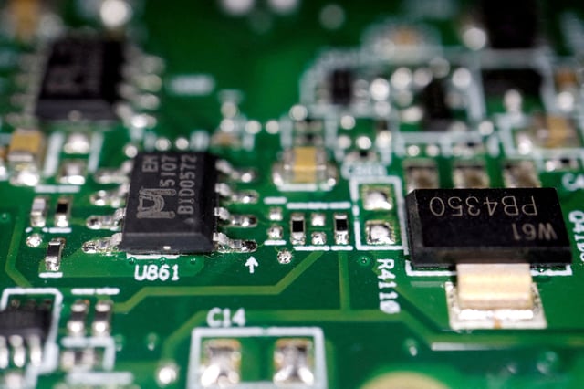 Semiconductor chips are seen on a printed circuit board in this illustration picture taken February 17, 2023. REUTERS/Florence Lo/Illustration/File Photo