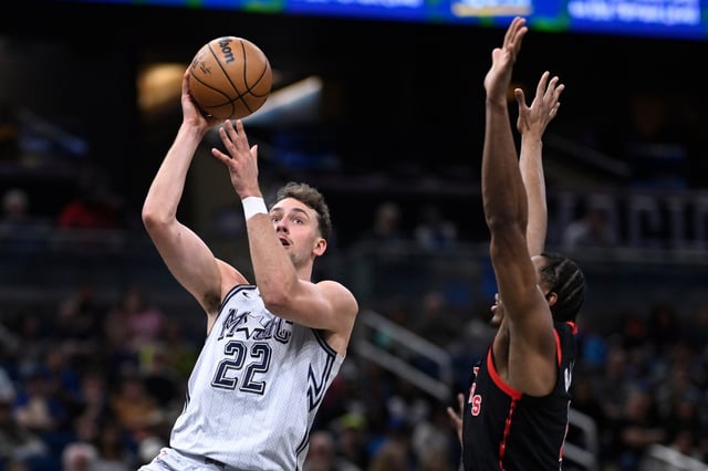 Orlando Magic forward Franz Wagner (22) goes up to shoot as Toronto Raptors forward Scottie Barnes defends during the first half of an NBA basketball game, Tuesday, March 4, 2025, in Orlando, Fla. (AP Photo/Phelan M. Ebenhack)