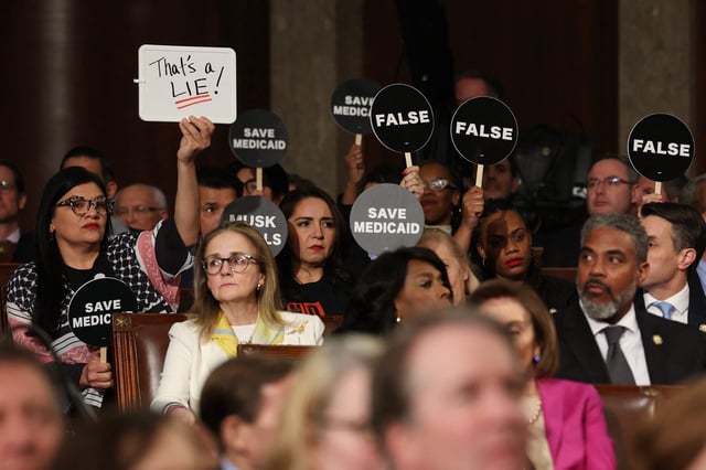 Democrats hold protest signs US President Donald Trump speaks during an address to a joint session of Congress at the US Capitol in Washington, DC, on March 4, 2025.