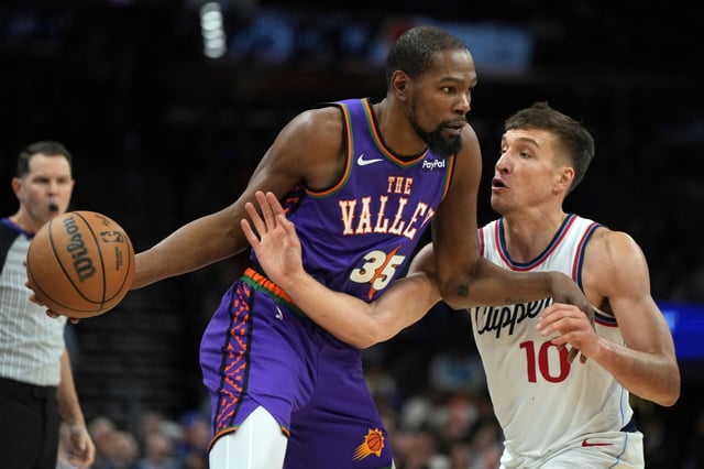 Phoenix Suns forward Kevin Durant shields the ball from Clippers guard Bogdan Bogdanovic during the first half on Tuesday night in Phoenix. Durant scored 19 of his team-high 34 points in the fourth quarter as the Suns erased a 19-point fourth-quarter deficit to beat the Clippers, 119-117. (AP Photo/Rick Scuteri)