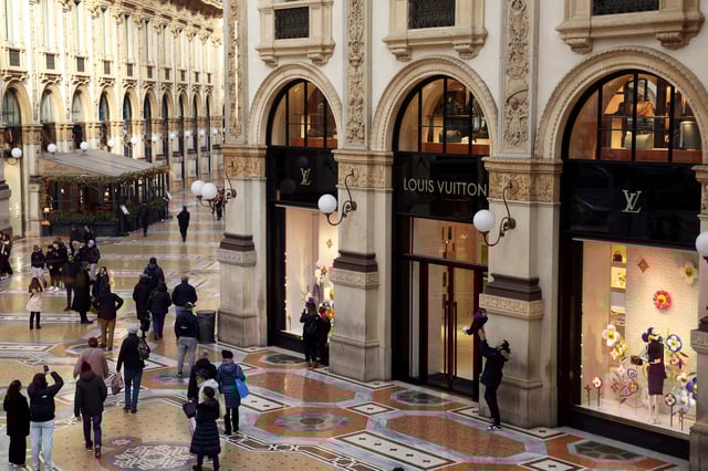 People walk outside a Louis Vuitton store in Galleria Vittorio Emanuele II in Milan, Italy, January 10, 2025. REUTERS/Claudia Greco/File Photo
