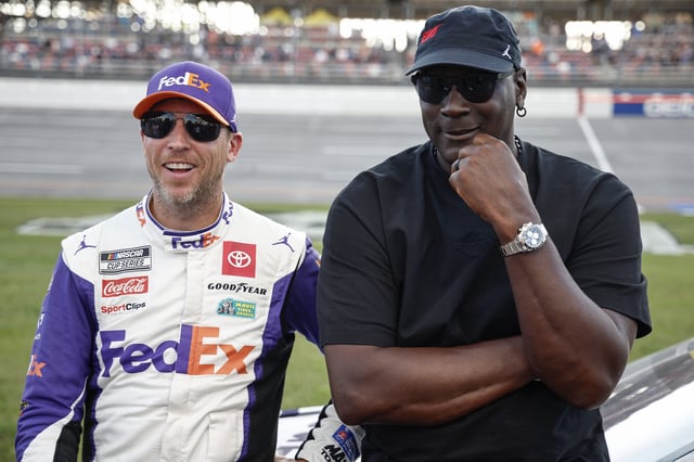 Co-owners of 23XI Racing, Denny Hamlin, driver of the #11 FedEx One Rate Toyota, and NBA Hall of Famer, Michael Jordan talk on the grid after the NASCAR Cup Series YellaWood 500 at Talladega Superspeedway on October 06, 2024 in Talladega, Alabama.