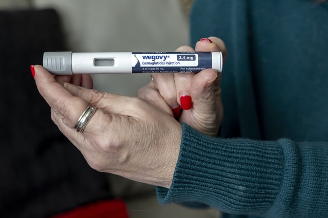 FILE - Donna Cooper holds up a dosage of Wegovy, a drug used for weight loss, at her home in Front Royal, Va., on Friday, March 1, 2024. (AP Photo/Amanda Andrade-Rhoades, File)