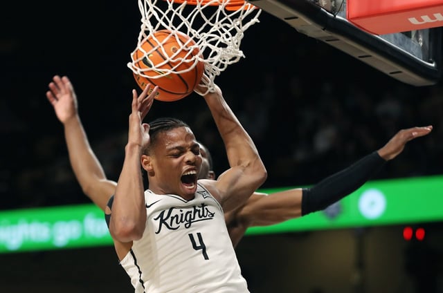 UCF guard Keyshawn Hall (4) slam dunks over Oklahoma State guard Brandon Newman (6) during the Oklahoma State at UCF basketball game at Financial Addition Arena in Orlando on Wednesday, March 5, 2025. (Stephen M. Dowell/Orlando Sentinel)
