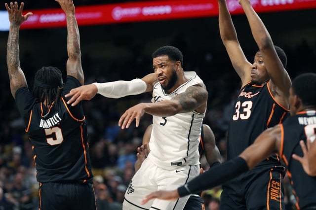 UCF guard Darius Johnson (3) passes among Oklahoma State defenders during the Oklahoma State at UCF basketball game at Financial Addition Arena in Orlando on Wednesday, March 5, 2025. (Stephen M. Dowell/Orlando Sentinel)