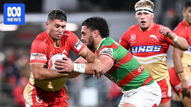 Jake Averillo runs the ball at the Rabbitohs defence during an NRL match.