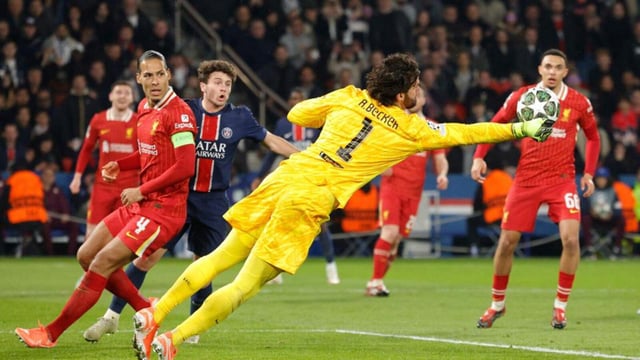 Liverpool goalkeeper Alisson (C) dives to punch the ball during their Champions League match against PSG. (AFP)