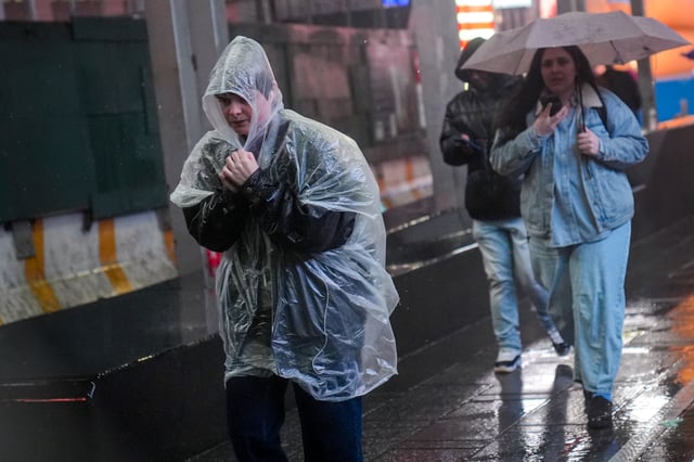 People walk during heavy rain in Manhattan, New York City, on Wednesday.