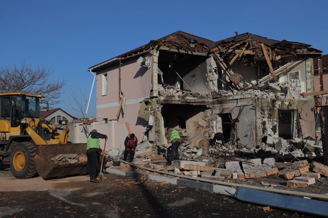 Workers clean the rubble of a building destroyed after a drone attack in Odesa on March 5, 2025.