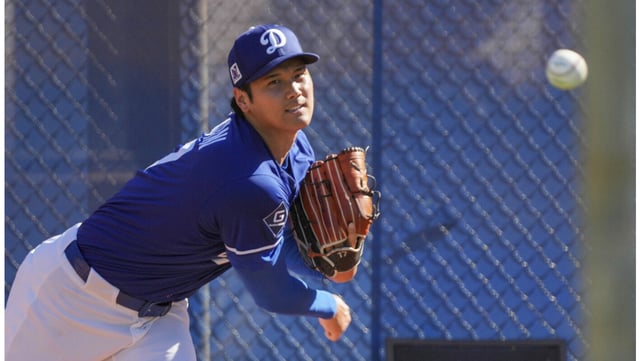 Dodgers star Shohei Ohtani throws during a spring training bullpen session on Feb. 25 in Glendale, Ariz. Ohtani has not thrown off a mound since that day, but Manager Dave Roberts says they are just slowing down Ohtani’s pitching rehab as he intensifies his work on offense. (AP Photo/Darryl Webb)