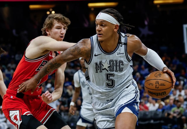 Orlando Magic forward Paolo Banchero (5) drives around Chicago Bulls forward Matas Buzelis, left, during the first half of an NBA basketball game, Thursday, March 6, 2025, in Orlando, Fla. (AP Photo/Kevin Kolczynski)