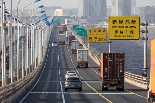 Trucks loaded with shipping containers pass over Donghai Bridge to exit Yangshan Port outside of Shanghai, China, February 7, 2025.  REUTERS/Go Nakamura     TPX IMAGES OF THE DAY/File Photo